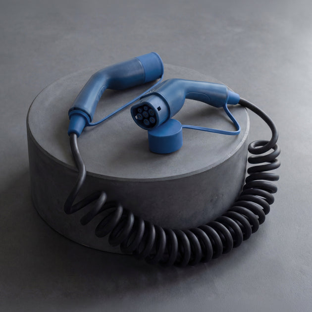 Coiled Type 2 EV charging cable resting on a round concrete pedestal
